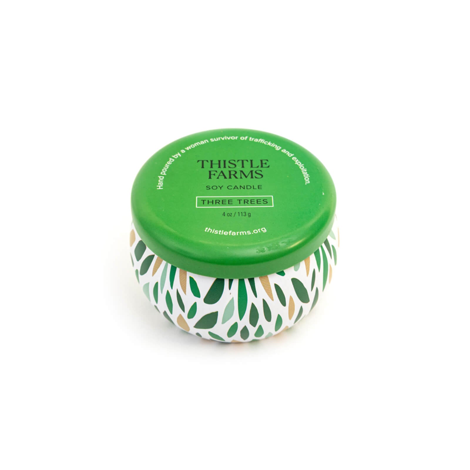 Thistle Farms soy candle with a green lid and a patterned base on a white background