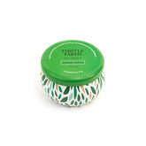 Thistle Farms soy candle with a green lid and a patterned base on a white background