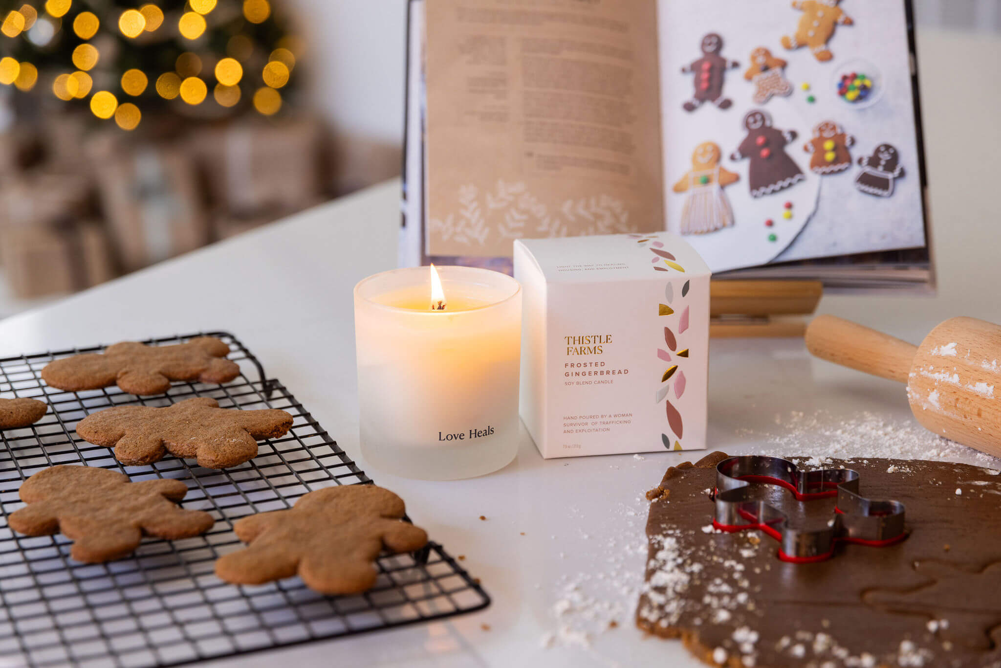 Love Heals candle burning near gingerbread cookies